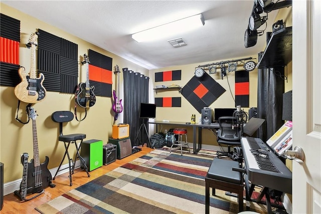 home office with visible vents, wood finished floors, and baseboards