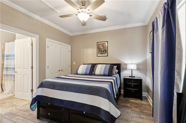 bedroom with light wood-style flooring, a closet, ornamental molding, attic access, and a ceiling fan