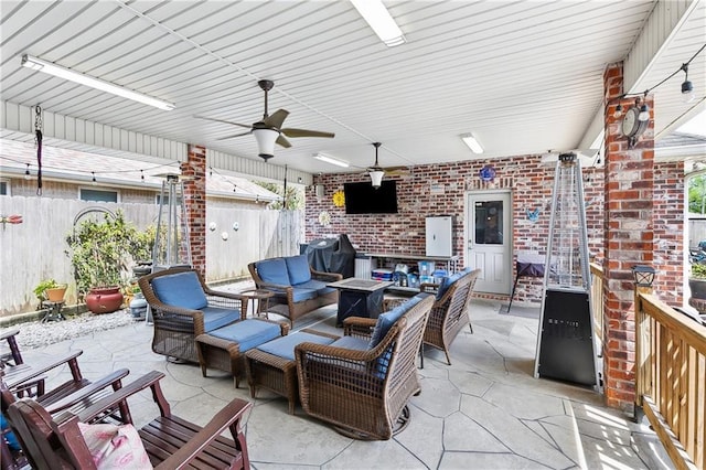 view of patio with fence, an outdoor living space with a fire pit, ceiling fan, and a grill