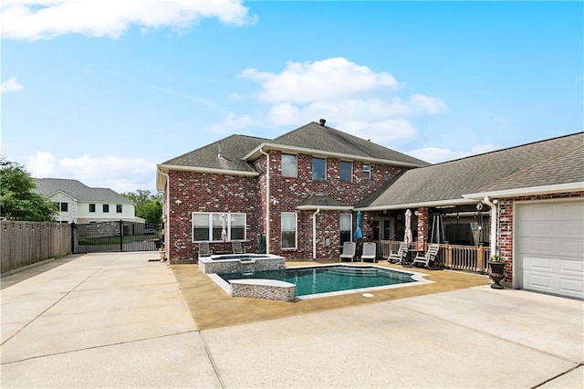 view of swimming pool with fence, a patio, and a pool with connected hot tub