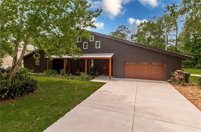 view of front facade featuring concrete driveway, an attached garage, a front lawn, and metal roof