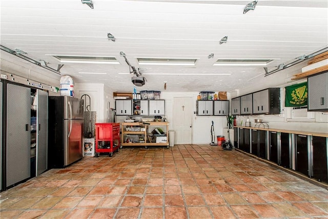 garage with freestanding refrigerator and a garage door opener