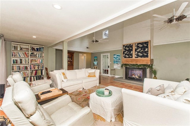 tiled living room featuring a large fireplace, ceiling fan, built in features, and recessed lighting