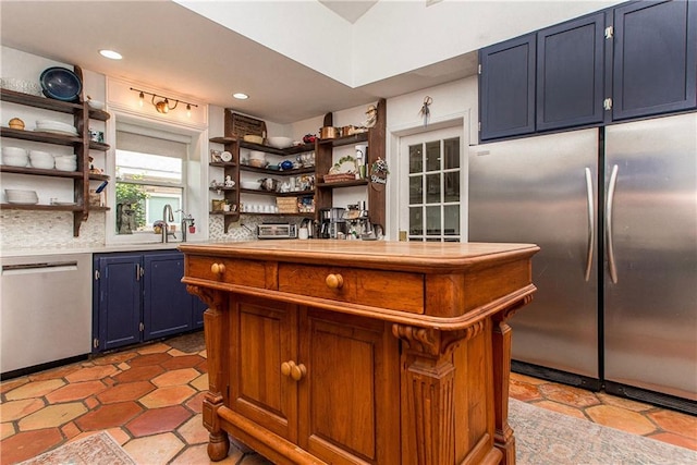 kitchen featuring blue cabinets, a sink, open shelves, and stainless steel appliances