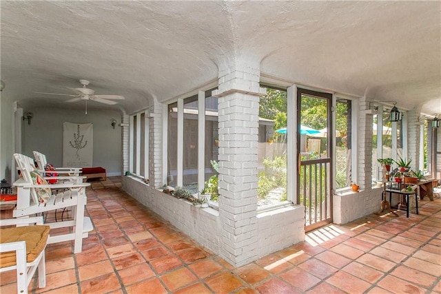 sunroom featuring a textured ceiling, a wall of windows, and plenty of natural light