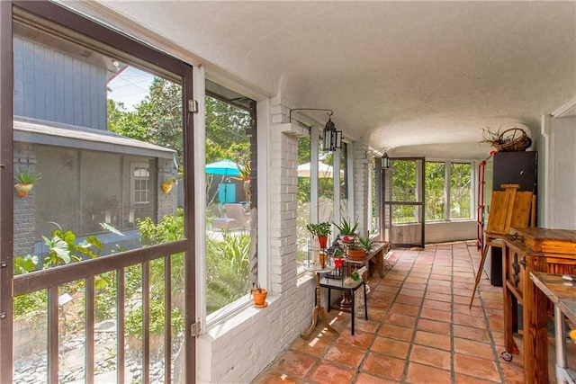sunroom / solarium with a healthy amount of sunlight and lofted ceiling