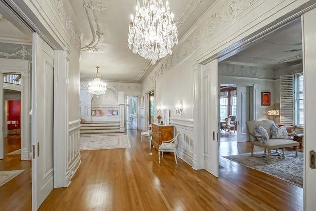 1711 Palmer Ave, New Orleans, LA 70118 - hallway featuring a chandelier, wood finished floors, ornamental molding, and a decorative wall