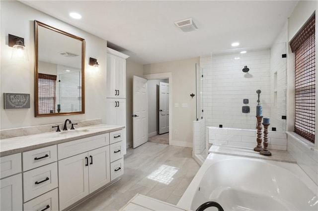 bathroom with a tile shower, visible vents, a bath, and vanity