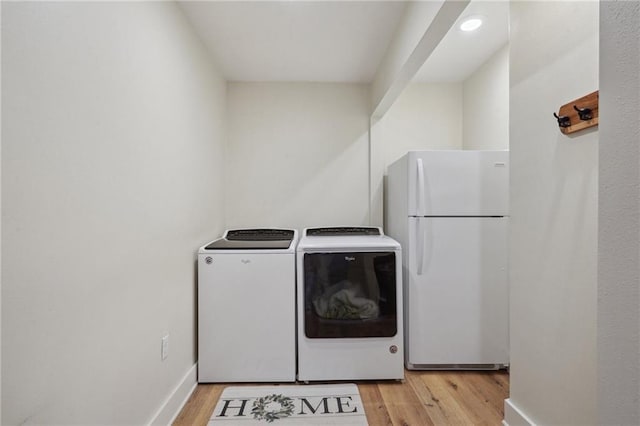 washroom featuring light wood-style flooring, independent washer and dryer, laundry area, and baseboards