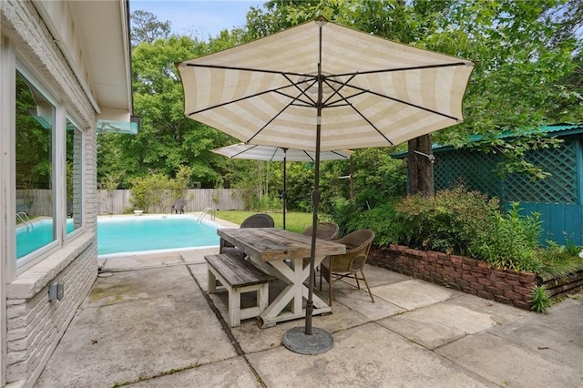 view of patio featuring outdoor dining space, a fenced backyard, and a fenced in pool