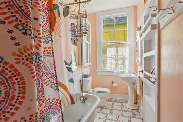 full bath with toilet, a washtub, a shower with curtain, and baseboards