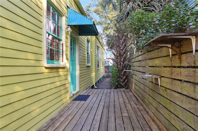 view of home's exterior with a deck and fence