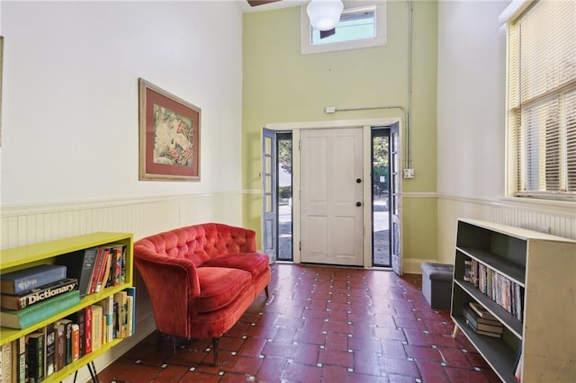 foyer entrance featuring a wainscoted wall and a high ceiling