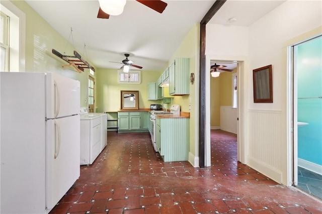 kitchen featuring green cabinetry, ceiling fan, wainscoting, and white appliances