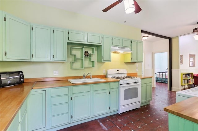 kitchen featuring a sink, under cabinet range hood, ceiling fan, gas range gas stove, and a toaster