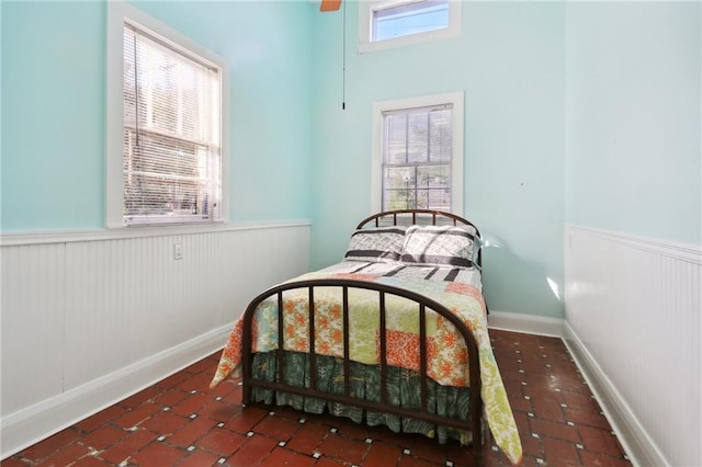 bedroom with baseboards and wainscoting