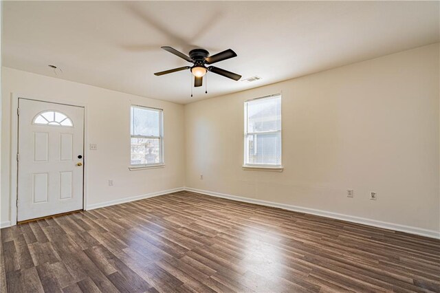 foyer entrance with dark wood-style flooring, a ceiling fan, and baseboards