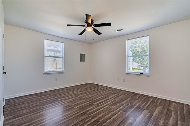 spare room featuring dark wood finished floors, baseboards, electric panel, and a ceiling fan