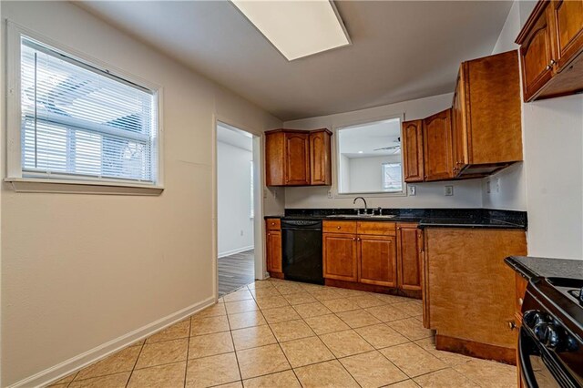 kitchen featuring black appliances, a sink, brown cabinetry, and light tile patterned floors