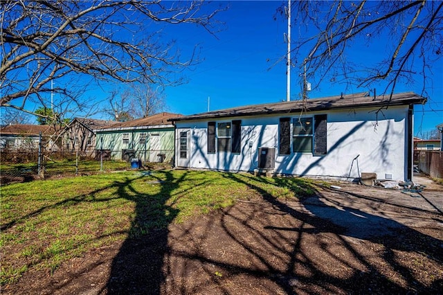 back of house featuring stucco siding and central AC unit
