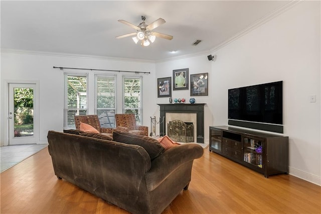 living room with a ceiling fan, visible vents, a healthy amount of sunlight, and light wood-style floors