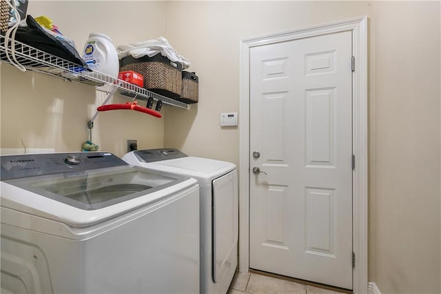 laundry area with separate washer and dryer, laundry area, and light tile patterned floors