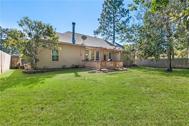 back of house with a yard, a deck, and a fenced backyard