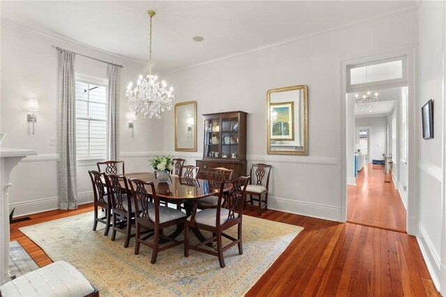 5934 Chestnut St, New Orleans, LA 70118 - dining room featuring hardwood / wood-style floors, baseboards, ornamental molding, and a notable chandelier