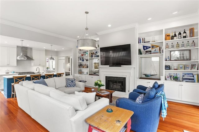 5934 Chestnut St, New Orleans, LA 70118 - living room featuring a glass covered fireplace, light wood-type flooring, recessed lighting, and ornamental molding