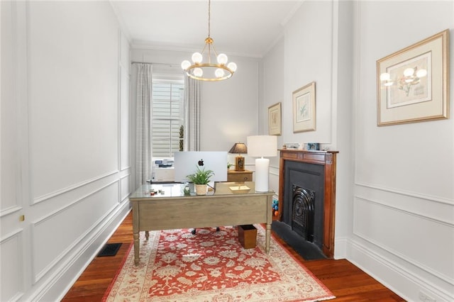 5934 Chestnut St, New Orleans, LA 70118 - office area featuring dark wood-style floors, a fireplace with flush hearth, a notable chandelier, a decorative wall, and ornamental molding