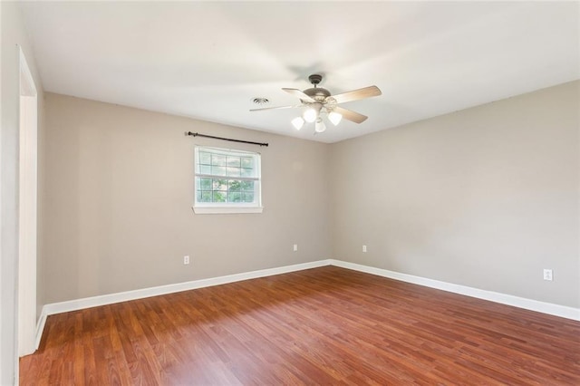 spare room featuring ceiling fan, wood finished floors, and baseboards