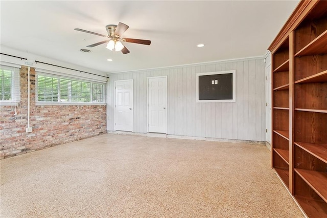 interior space with recessed lighting, a ceiling fan, and brick wall
