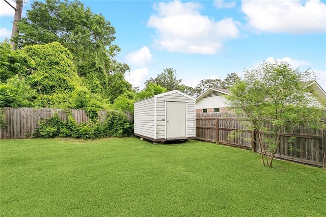 view of yard with an outdoor structure, a fenced backyard, and a storage shed