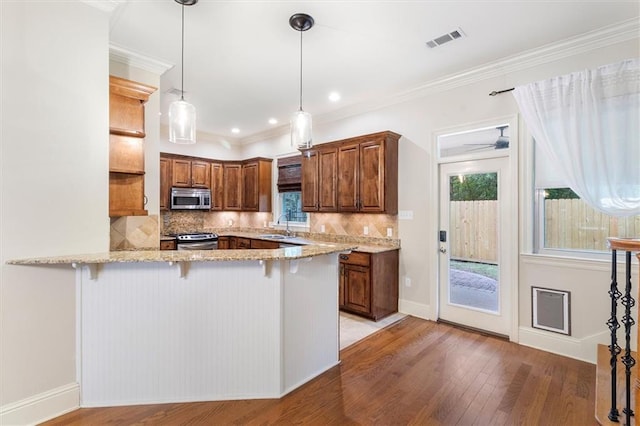 kitchen featuring a sink, appliances with stainless steel finishes, visible vents, light wood finished floors, and a peninsula