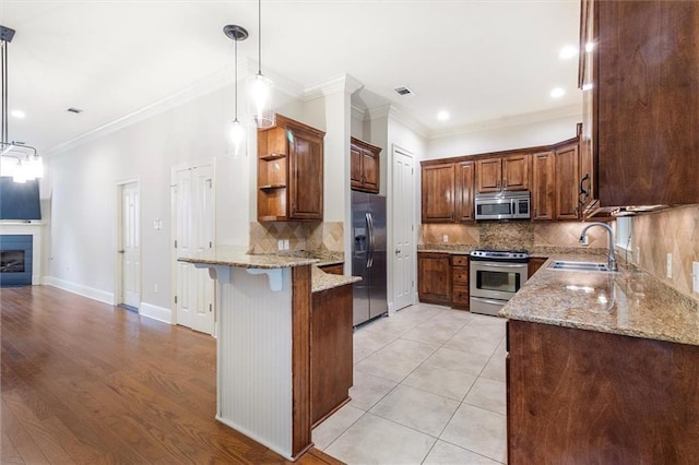 kitchen featuring open shelves, a sink, appliances with stainless steel finishes, a peninsula, and backsplash