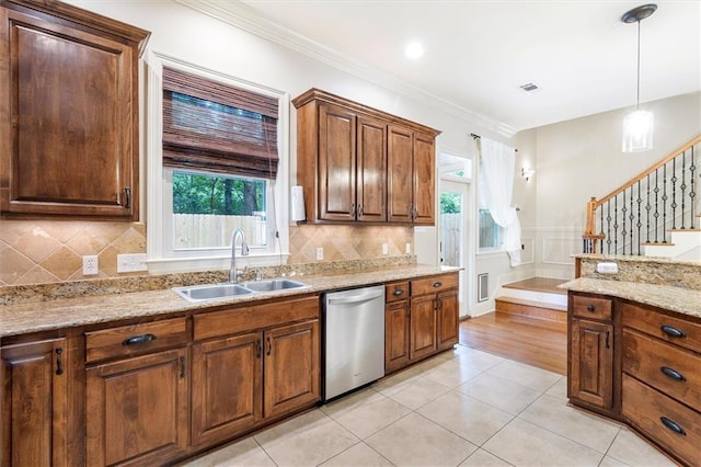 kitchen featuring decorative light fixtures, plenty of natural light, stainless steel dishwasher, and a sink