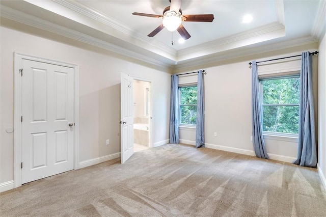 unfurnished bedroom with baseboards, ornamental molding, carpet floors, and a tray ceiling