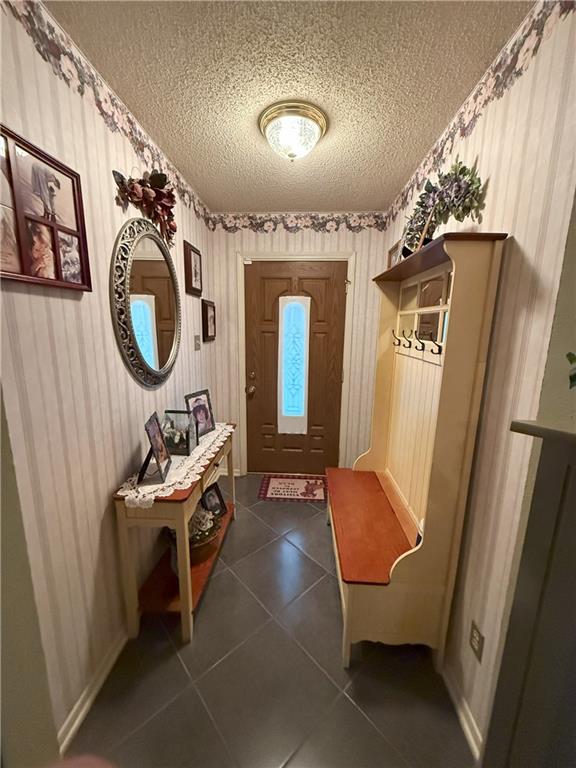 2053 Saulet Pl, Harvey, LA 70058 - mudroom featuring a textured ceiling and dark tile patterned floors