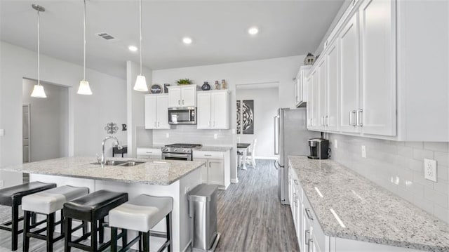 5520 Wake Reserve Rd, Slidell, LA 70461 - kitchen with white cabinets, appliances with stainless steel finishes, a sink, a kitchen island with sink, and tasteful backsplash