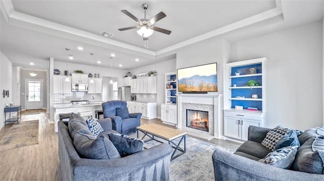 5520 Wake Reserve Rd, Slidell, LA 70461 - living area with a raised ceiling, light wood finished floors, a ceiling fan, recessed lighting, and visible vents