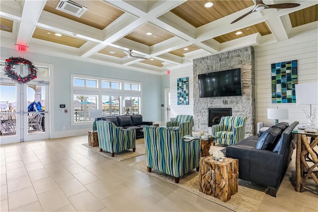 5520 Wake Reserve Rd, Slidell, LA 70461 - tiled living room featuring beam ceiling, a stone fireplace, a ceiling fan, visible vents, and coffered ceiling