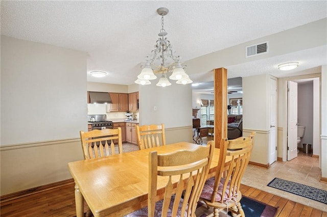 622 Pennsylvania Ave, Slidell, LA 70458 - dining room with a textured ceiling, visible vents, baseboards, an inviting chandelier, and light wood-type flooring