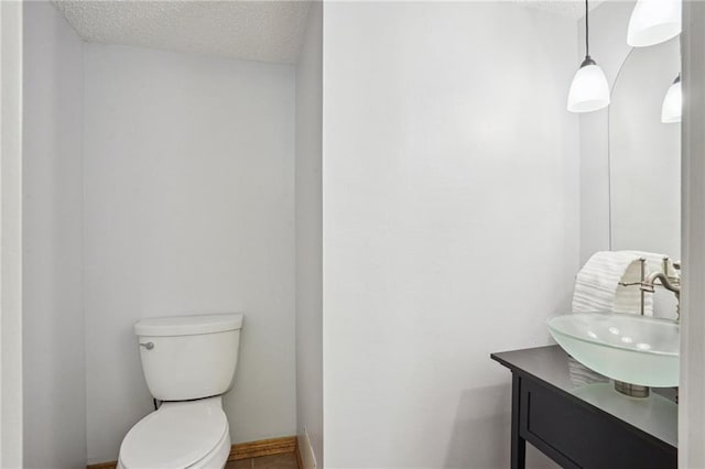 622 Pennsylvania Ave, Slidell, LA 70458 - bathroom featuring toilet, a textured ceiling, vanity, and baseboards