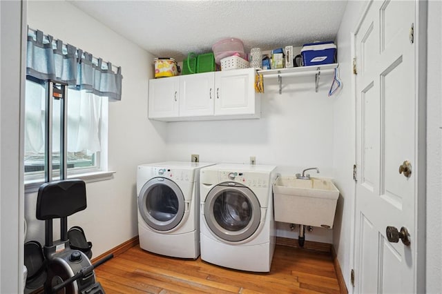 622 Pennsylvania Ave, Slidell, LA 70458 - laundry room with cabinet space, washer and clothes dryer, light wood finished floors, and a sink