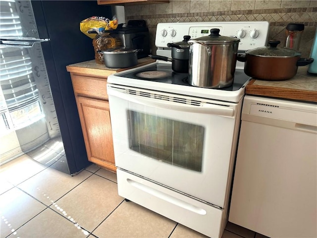 2500 Manson Ave Unit 404, Metairie, LA 70001 - kitchen with light tile patterned floors, white appliances, tile countertops, and decorative backsplash