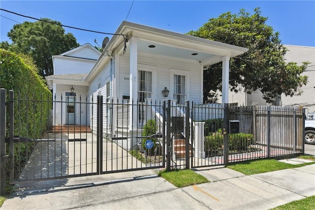 616 Cadiz St, New Orleans, LA 70115 - shotgun-style home with a porch, a fenced front yard, and a gate