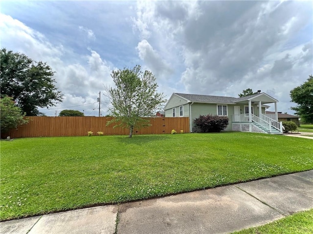 view of home's exterior with fence, a lawn, and a porch
