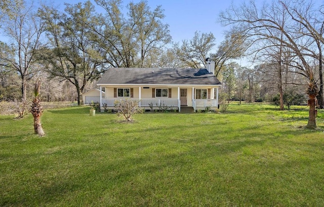 bungalow-style house with covered porch, a chimney, a front lawn, and a detached garage