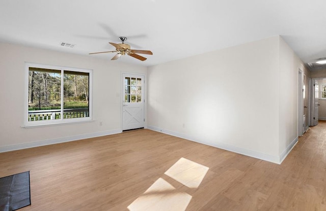 spare room with a ceiling fan, baseboards, and light wood-type flooring