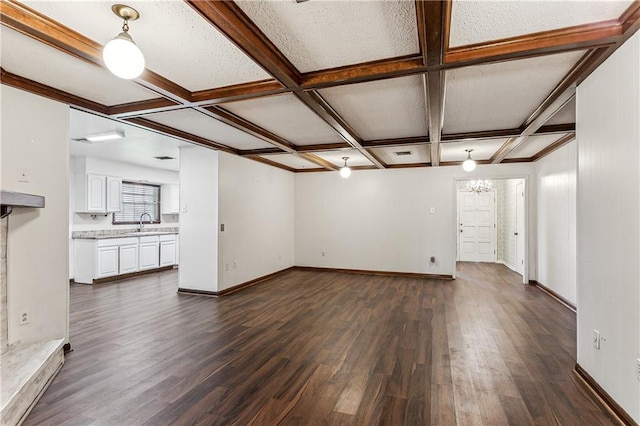 194 Sedgefield Dr, Harahan, LA 70123 - unfurnished living room with dark wood-style floors, coffered ceiling, baseboards, a sink, and beam ceiling